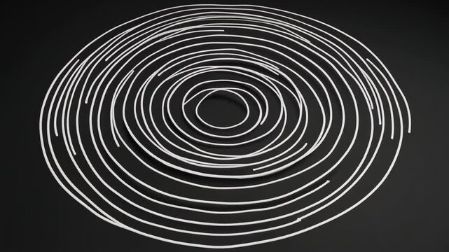 Coiled white wire arranged in spiral pattern on dark surface, showcasing geometric symmetry, precision, and concentric design.