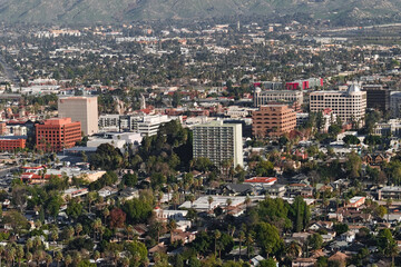 Obraz premium Elevated view of downtown Riverside, California with office buildings, neighborhoods, and mountains in the background.