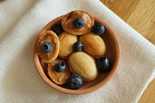 Homemade nut-shaped cookies with boiled condensed milk. A sweet dessert made from dough. Oven-baked pastry dessert.