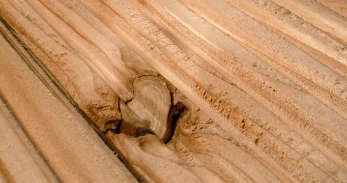 Close-up of weathered wooden plank with prominent knot and grain