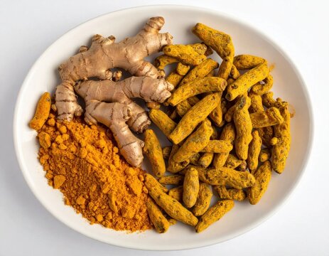 Fresh ginger root with dried turmeric fingers and yellow powder on white plate, spice seasoning for healthy cooking and herbal medicine