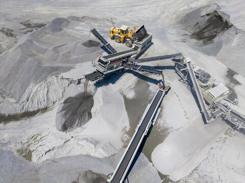 Granite quarry operation showing machinery, tools, and raw materials in use at a mining site during daylight hours for stone extraction