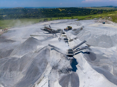 Granite quarry work in progress with machinery processing stone at a remote location under clear skies during daylight hours