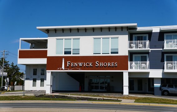 Fenwick Island, Delaware, U.S.A - May 22, 2026 - Modern multi-story Fenwick Shores building featuring lighthouse-themed signage, balconies, and coastal architectural elements along roadside.