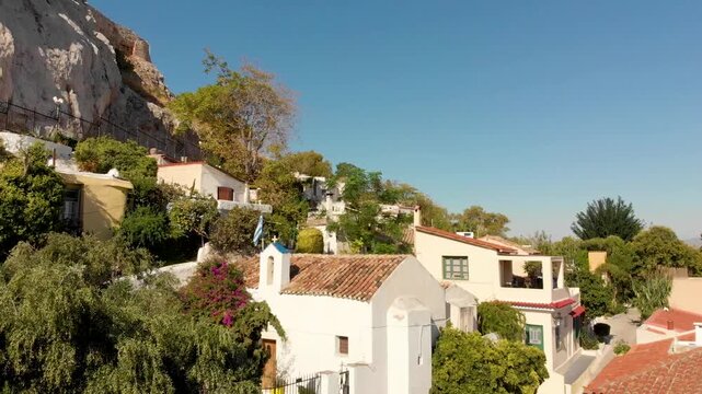 Aerial view of Anafiotika Plaka district in Athens, church and houses, Greece near Acropolis hill. Drone view from above. Plaka picturesque district below, Athens historic centre, Attica, Greece
