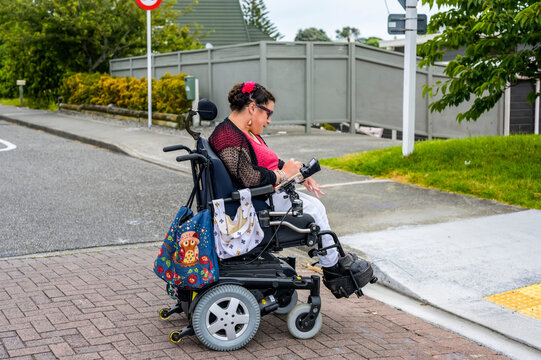 Maori woman with Cerebral Palsy in a wheelchair crossing a street
