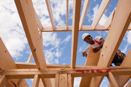 Low angle view of a carpenter measuring bevel on rafter