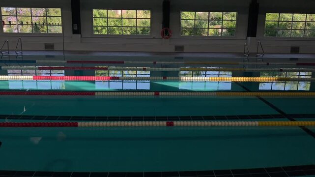 Modern swimming pool with window reflections and soft lateral camera movement