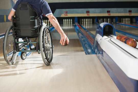 Rear view of a man with a Spinal Cord Injury playing ten pin bowling