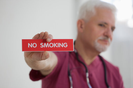 Doctor holding no smoking sign