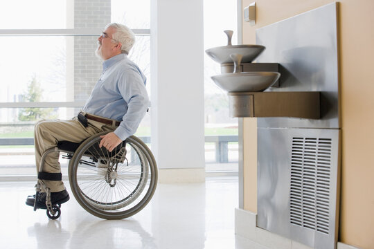 University professor with Muscular Dystrophy in a wheelchair in a corridor