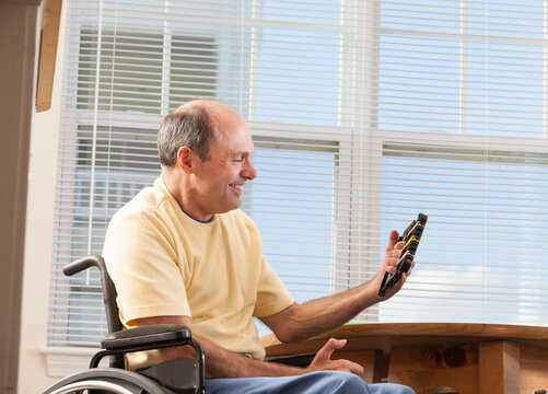 Man with Friedreich's Ataxia with deformed hands using hand strengthening equipment
