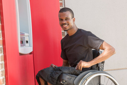 Man in a wheelchair who had Spinal Meningitis using a bank ATM