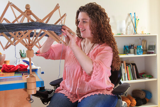 Woman with Muscular Dystrophy working with her umbrella yarn winder on her power chair