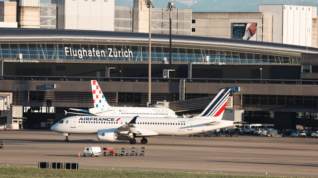 Zurich, Switzerland - May 29, 2025: Airplanes parked at Zurich Airport with terminal building in background during daylight