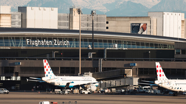 Zurich, Switzerland - May 29, 2025: Zurich airport with planes on the runway and mountains in the daytime