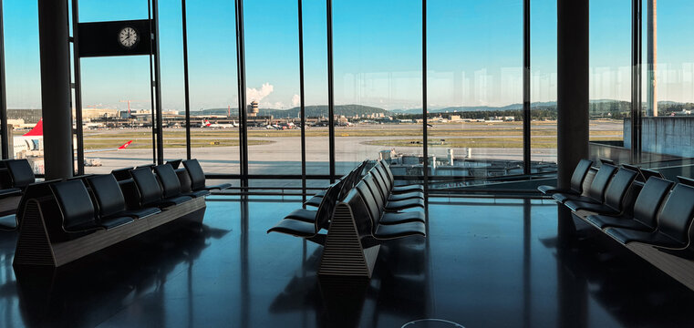 Zurich, Switzerland - May 29, 2025: Modern waiting area at Zurich Airport with a clear view of runway and distant mountains