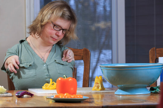 Woman with TAR Syndrome preparing vegetables for dinner in the kitchen