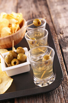 vermouth shots with green olives and potato chips appetizer tray