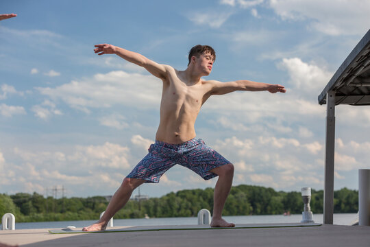 Young man with Down Syndrome exercising on a dock