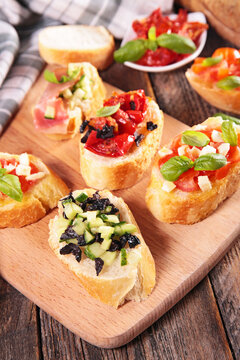 assorted Italian bruschetta and crostini appetizers on wooden board