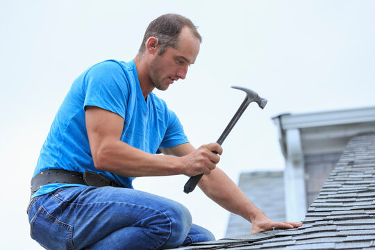 Roofer with hearing aid on his ear working on the new roof