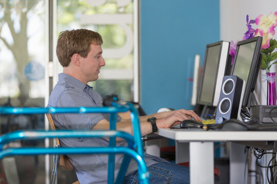 Young man with Cerebral Palsy working on his computer