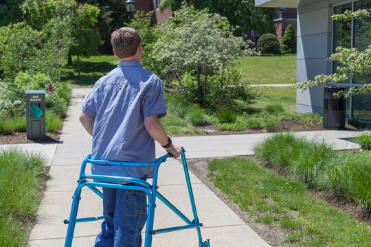 Young man with Cerebral Palsy using his walker to walk to work