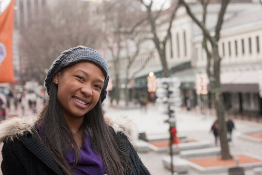 Portrait of a young woman with a city scene behind her