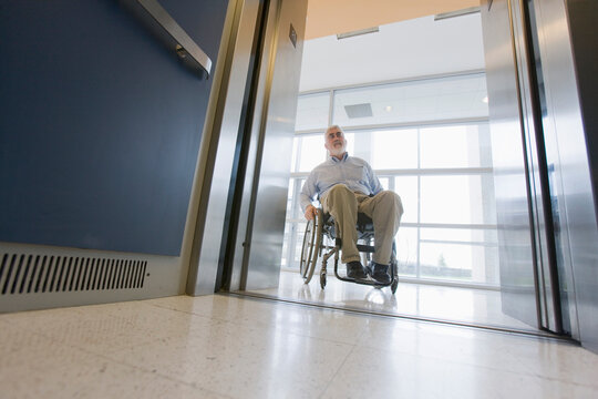University professor with Muscular Dystrophy in a wheelchair entering an elevator