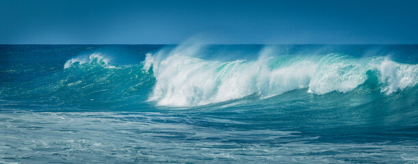 Dynamic ocean waves break with spray against the coast under a blue sky, Fuerteventura, Canary Islands, Spain © Fotografierereien