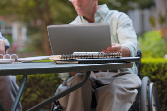 Businessman with spinal cord injury working on a laptop