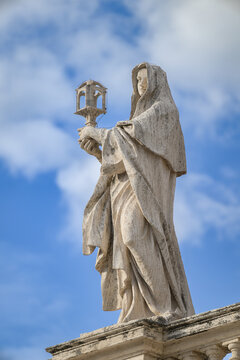 Saint Clare of Assisi, sculpted by Lazzaro Morelli, atop the North Colonnade of St Peter&rsquo;s Basilica in Vatican, Rome, Italy.