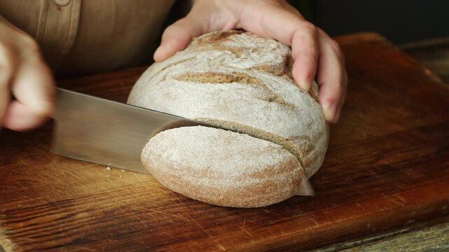 Cutting a rustic country bread. Freshly baked loaf of gluten free bread