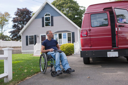Man with spinal cord injury in a wheelchair getting in his accessible van with a remote