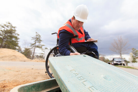 Man in wheelchair working on underground cables