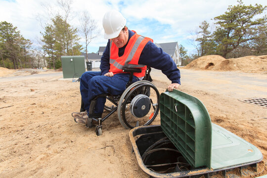 Man in wheelchair working on underground cables