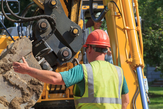 Construction foreman guiding excavator operator
