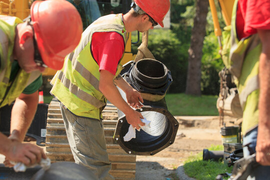 Construction workers guiding water main into place