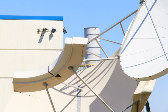 Satellite dishes with electrical power plant in background