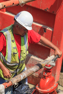 Construction worker using wrench to open gate valve