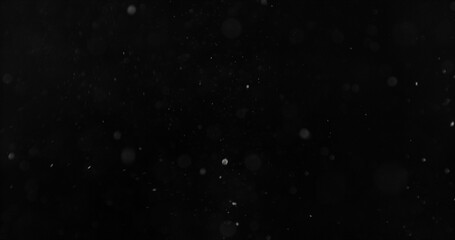 Realistic falling snow and airborne dust particles drifting through dark space. Atmospheric winter storm effect on black background, ideal for overlays, VFX compositing and cinematic scenes. © Jag_cz