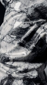 Abstract polished marble sculpture with deep grey veins and high gloss finish, illuminated by cinematic dramatic lighting, creating a luxury interior design aesthetic with rich monochromatic textures.