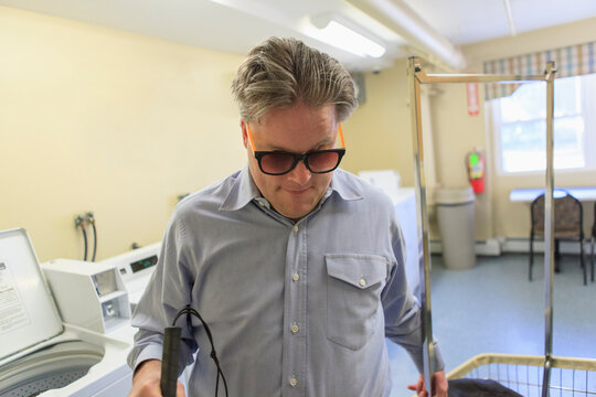 Man with congenital blindness pulling the laundry cart in the laundry room