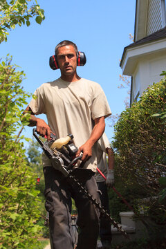 Landscaper with an electric weed trimmer and ear protectors