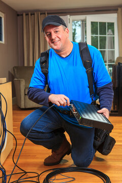Service man connecting cable to modem box for home TV