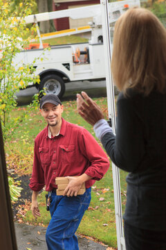 Cable installer leaving and waving to homeowner