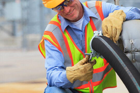 Electrical engineer inspecting hose connection for cooling supply lines at power plant