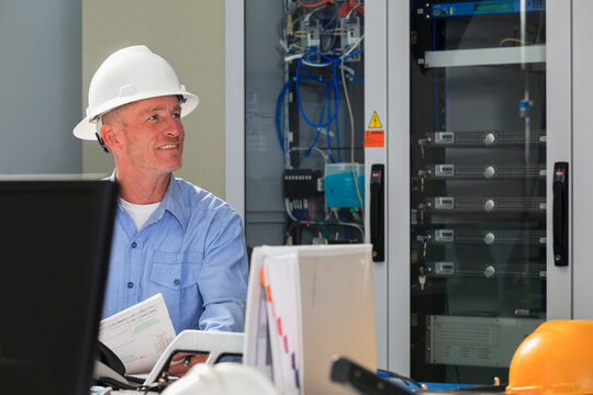 Electrical engineer working with switches and servers in broadband communication hub