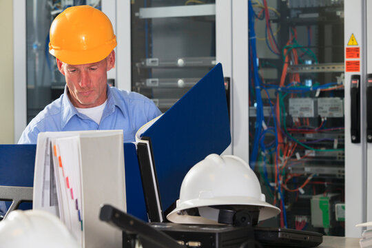 Electrical engineer reviewing data logs in broadband communication hub